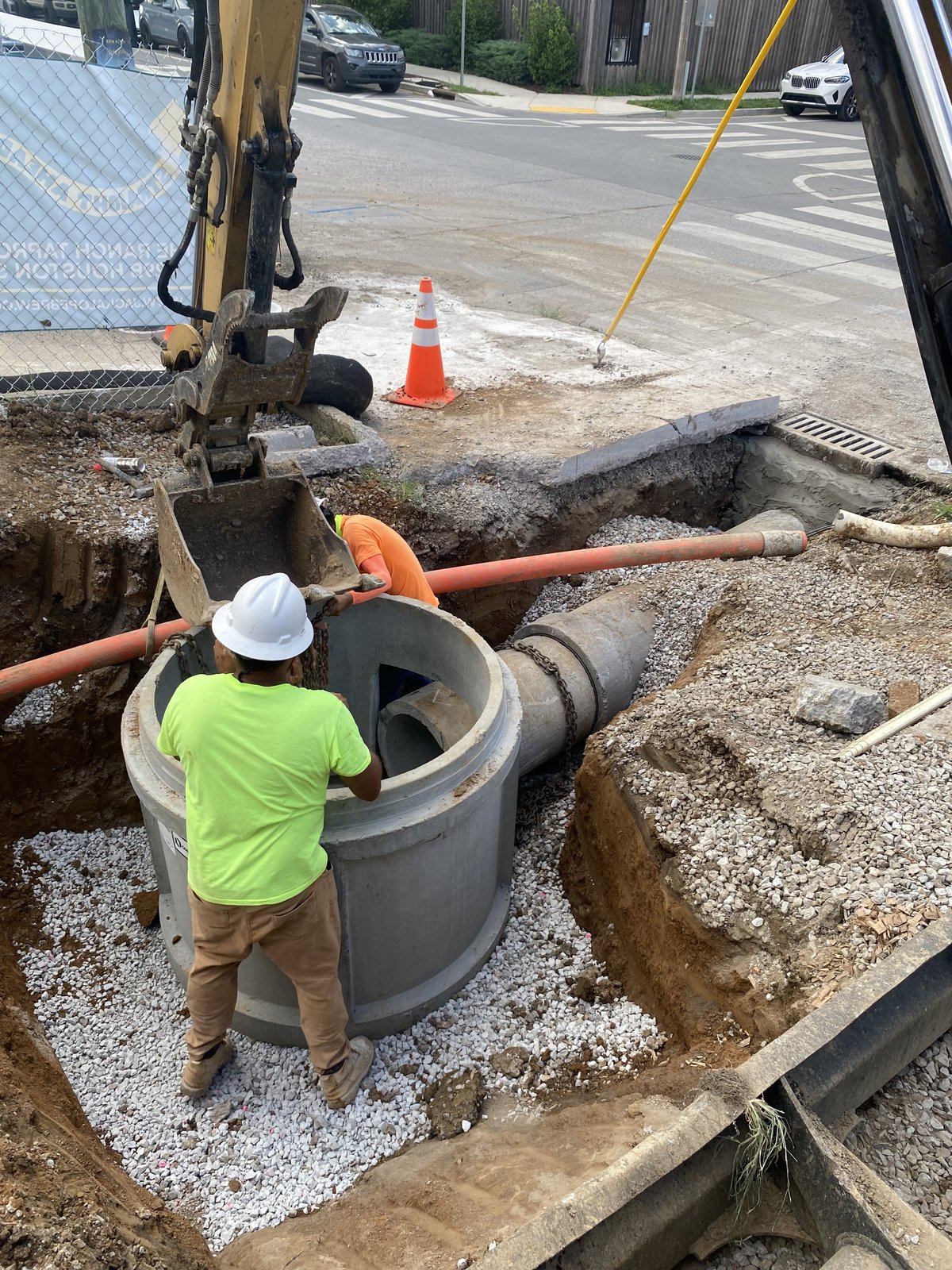 PMT Site crew setting a precast concrete manhole structure with an excavator, Nashville